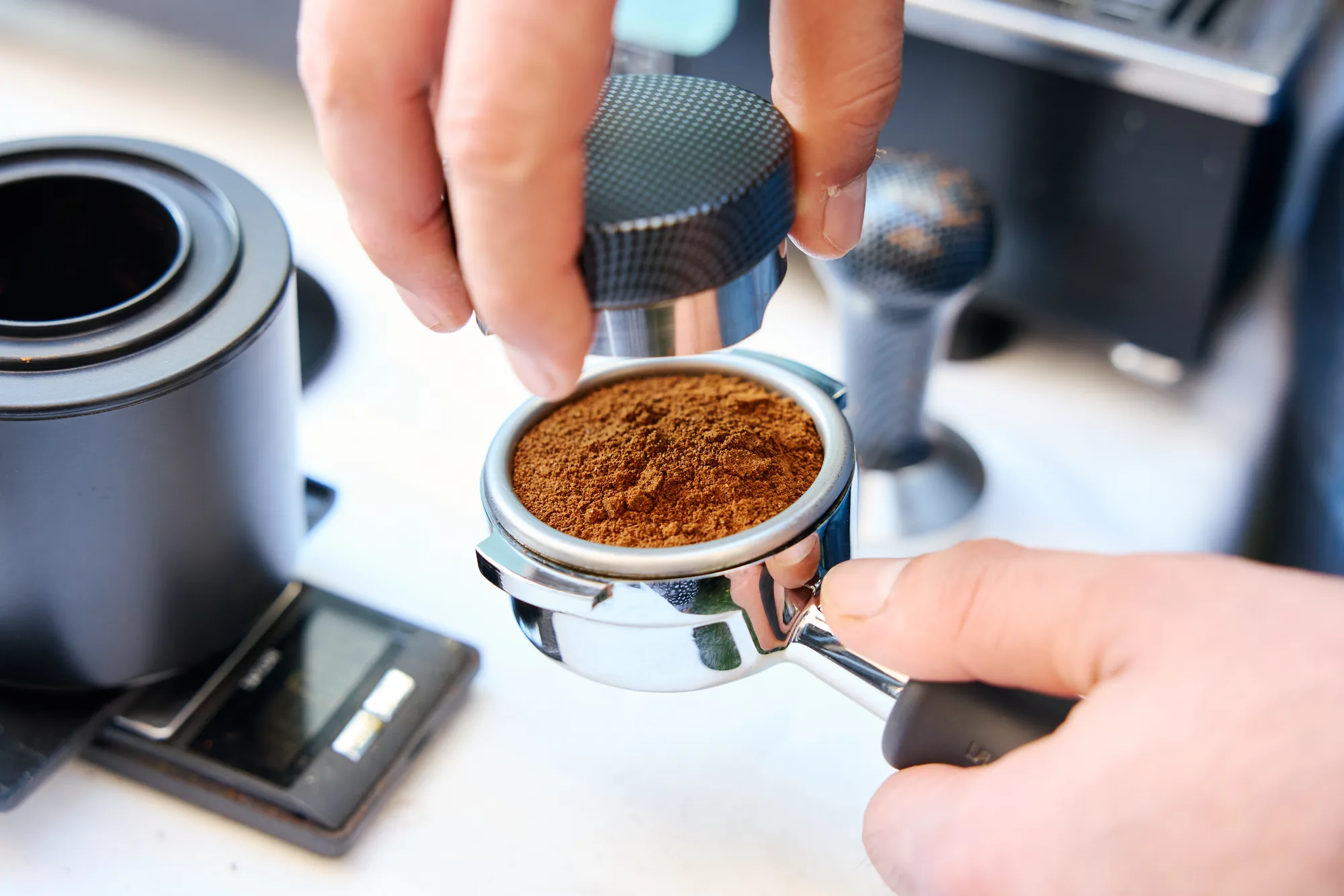 Prensando el café molido recién molido en el portafiltro