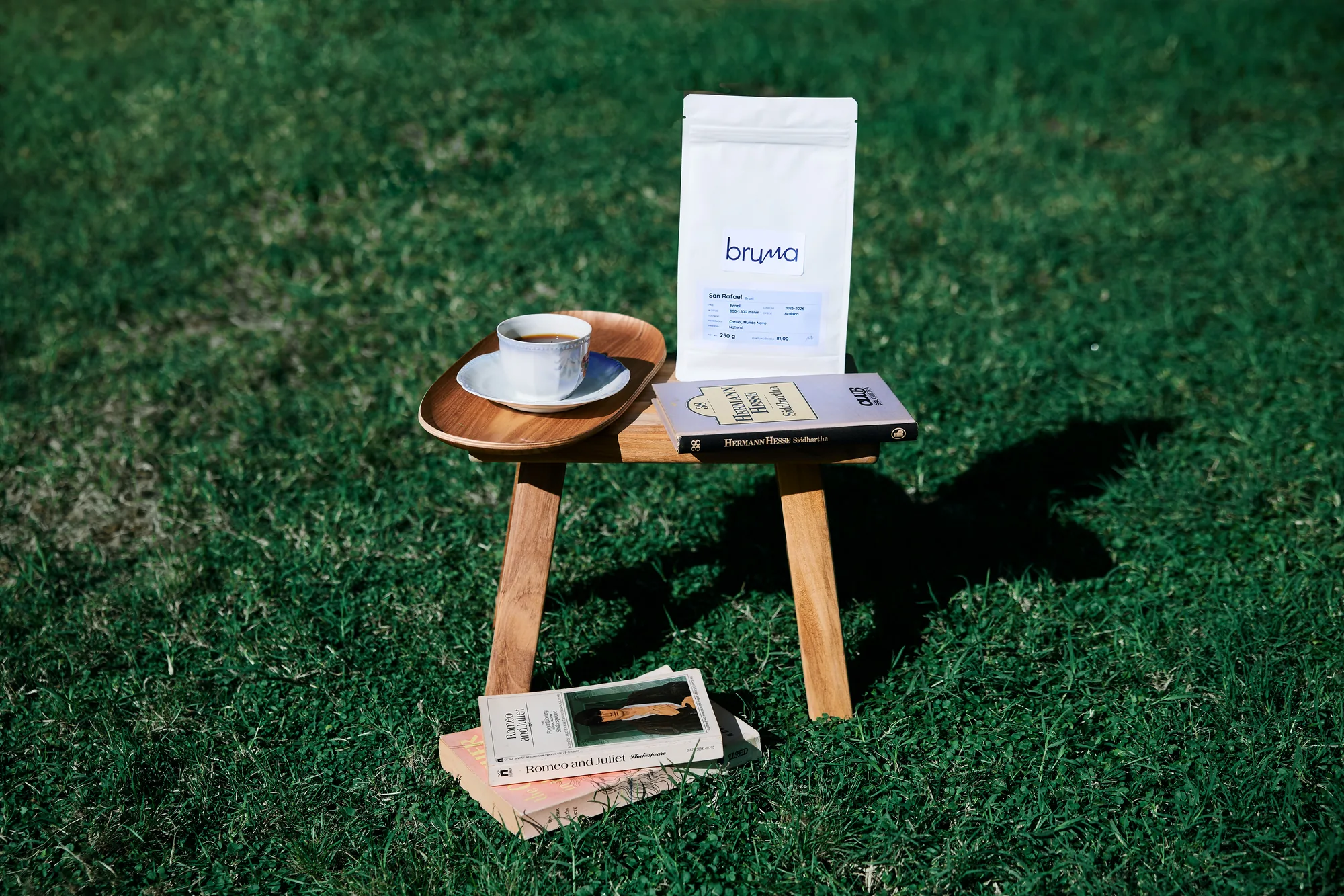 Unha bolsa de café Bruma e unha cunca sobre un taburete na herba
